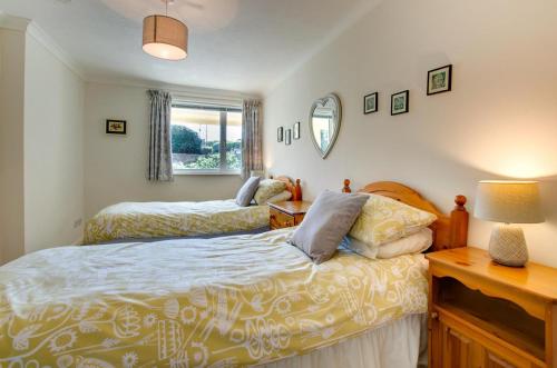 Un dormitorio con dos camas y una mesa y un espejo. en Flat 24 Clifton Court, en Croyde
