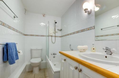 Un baño blanco con lavabo e inodoro. en Flat 24 Clifton Court, en Croyde