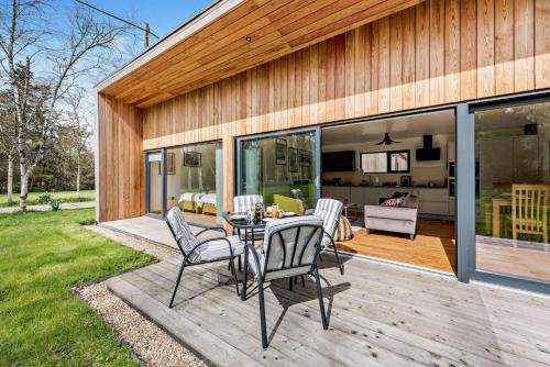 a patio with a table and chairs on a deck at River Birch in Beckley