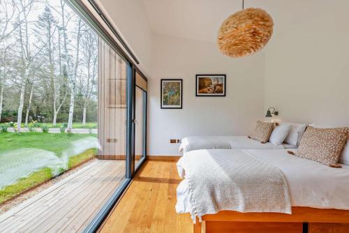 two beds in a bedroom with a large window at River Birch in Beckley
