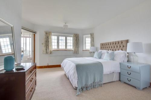 ein weißes Schlafzimmer mit einem großen Bett und einer Kommode in der Unterkunft Rockmount in Saint Margaretʼs at Cliffe