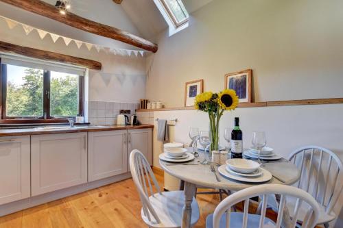 a kitchen and dining room with a table and chairs at Cranscombe Barn in Countisbury
