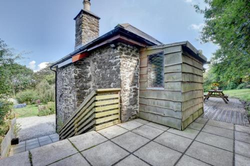 a small building with a chimney on a patio at Cranscombe Barn in Countisbury