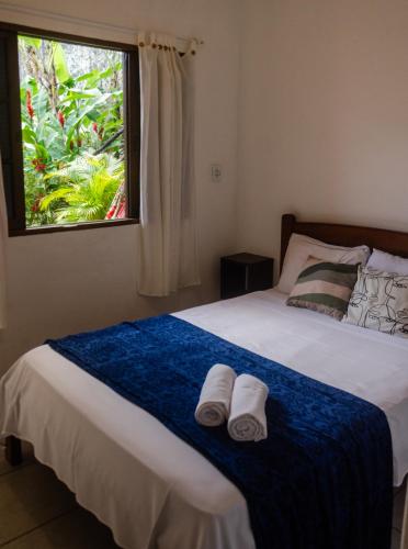 a bedroom with a bed with towels on it at Pousada Pitaya Maresias in Maresias