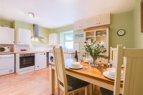 a kitchen with a wooden table and a dining room at Nigel House in Mousehole
