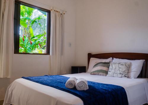 a bedroom with a bed with two towels on it at Pousada Pitaya Maresias in Maresias