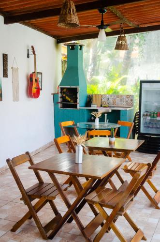 a dining room with a wooden table and chairs at Pousada Pitaya Maresias in Maresias