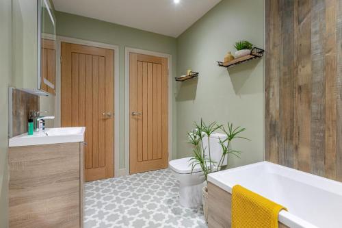 a bathroom with a tub and a toilet and a sink at Swallows Nest - Barnard Castle in Wycliffe