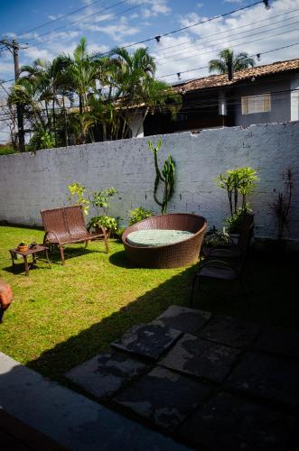 a garden with a bench and a fire pit and a fence at Pousada Pitaya Maresias in Maresias