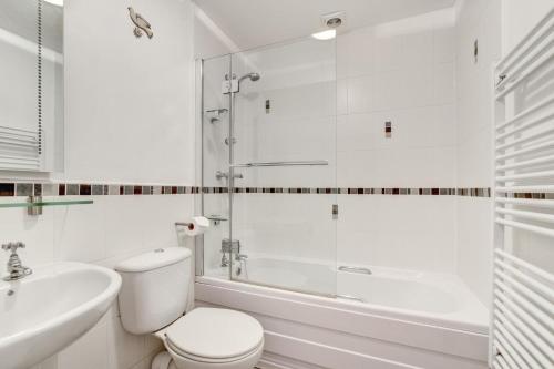 ein weißes Badezimmer mit Toilette und Dusche in der Unterkunft Elterwater Apartment in Bowness-on-Windermere