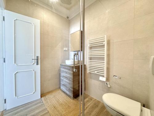 a bathroom with a toilet and a glass door at Quarteira Central Beach 5 by Homing in Cavacos