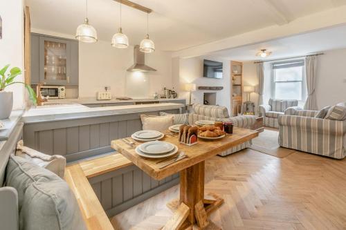 a kitchen and living room with a table with food on it at Mole End in Fowey