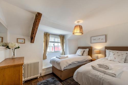 ein Schlafzimmer mit zwei Betten und einem Fenster in der Unterkunft Annies Cottage - Appledore in Appledore
