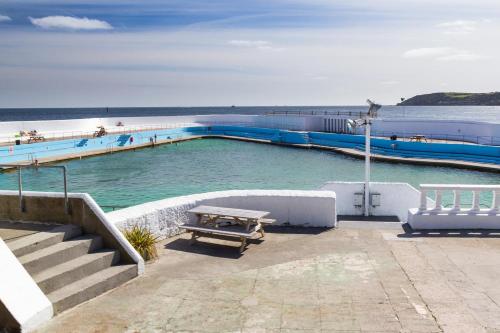 a swimming pool with a picnic table in the water at Pebbles Marazion in Marazion