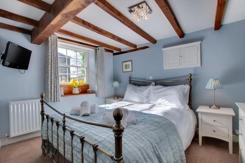 a bedroom with a bed and a tv in a room at Rooks Cottage in Askrigg