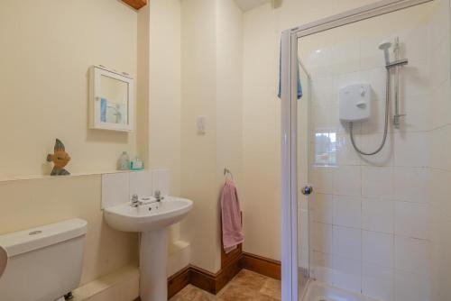 Lark Rise Cottage - 3 White Hoe Farm في Kirton in Lindsey: حمام أبيض مع حوض ودش