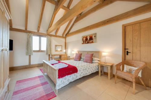 a bedroom with a bed and a table and a chair at The Old Cowshed in Stone