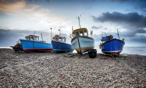 a group of boats sitting on a rocky beach at Beer View in Beer