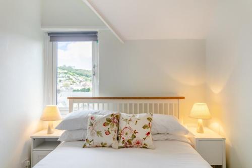 a bedroom with a bed with two lamps and a window at Beer View in Beer