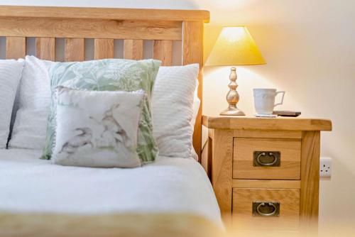 a bedroom with a bed with a lamp on a night stand at Vallum at Hadrians Wall in Irthington