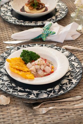 a plate of food on top of a table at Hotel Agua Azul Beach Resort in Baru