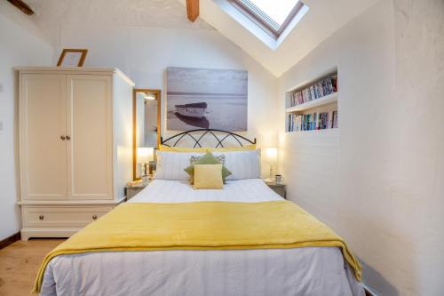 a bedroom with a large bed with a yellow blanket at Bodlondeb in Abererch