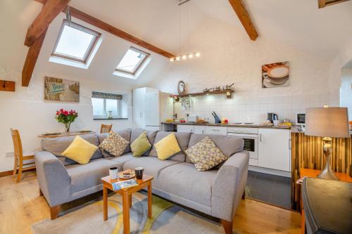 a living room with a couch and a kitchen at Bodlondeb in Abererch