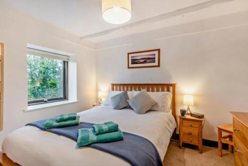 a bedroom with two beds and a window at Rosie Cottage in Bassenthwaite