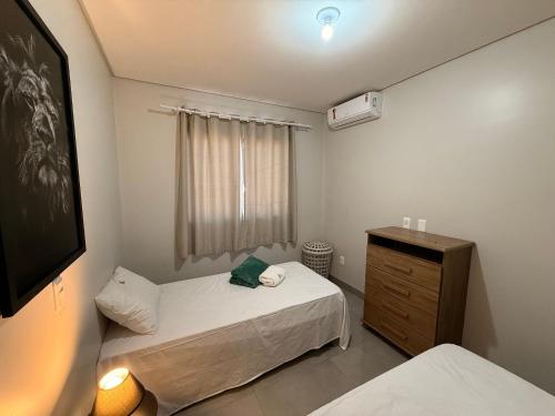 a small bedroom with two beds and a dresser at Lindo apartamento de 2/4 com ar condicionado em prédio familiar in Barreiras