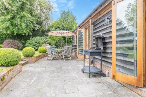 a patio with a table and an umbrella at Little Gable in Berrington