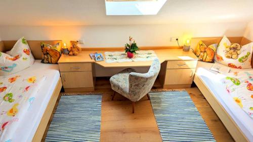 a room with two beds and a desk in it at Ferienwohnung Wannenblick, Ferienhof Lochbihler, WertachAllgäu in Wertach