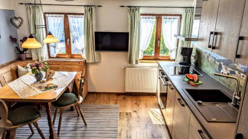 a kitchen with a table and a sink and a stove at Ferienwohnung Wannenblick, Ferienhof Lochbihler, WertachAllgäu in Wertach