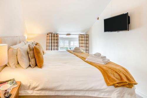 a bedroom with a large bed and a flat screen tv at Llety-Cariad in Trecastle