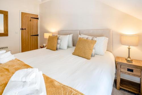 a bedroom with a large white bed with pillows at Llety-Cariad in Trecastle
