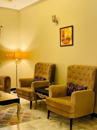 a living room with two chairs and a couch at Majestic Family Lodges in Islamabad