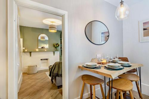 a dining room with a table and chairs and a mirror at Trehawn Cottage in Saint Columb Major