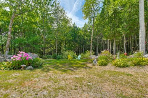 a garden with flowers and rocks and trees at Explore Coastal Maine! Cozy Apt with Yard and Garden in Orland
