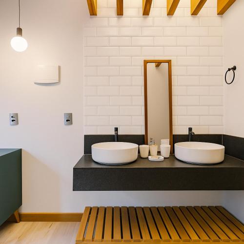 a bathroom with two sinks and a mirror at Pousada Flores do Cerrado in Pirenópolis