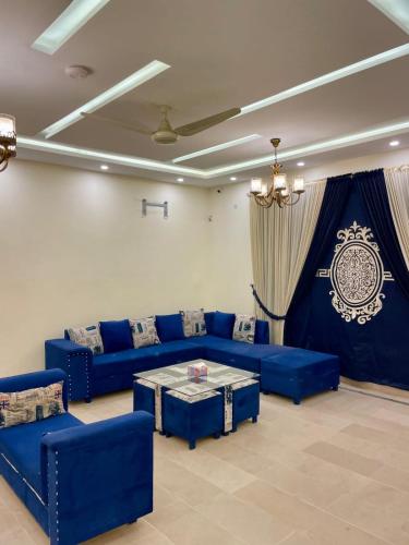 a living room with blue couches and a table at Majestic Family Lodges in Islamabad