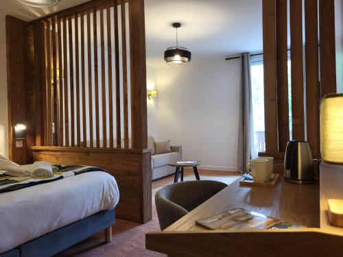 a hotel room with a bed and a desk and a table at Mille100-47 - Ubaye Base Camp in Faucon-de-Barcelonnette