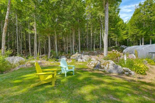 two chairs and a table in a yard with trees at Explore Coastal Maine! Cozy Apt with Yard and Garden in Orland