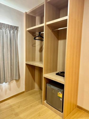 a walk in closet with a microwave in it at Tiamo Kohlarn in Ko Larn