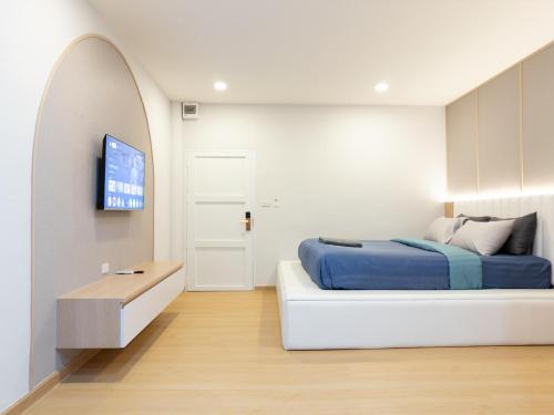 a bedroom with a bed and a tv on a wall at Tiamo Kohlarn in Ko Larn