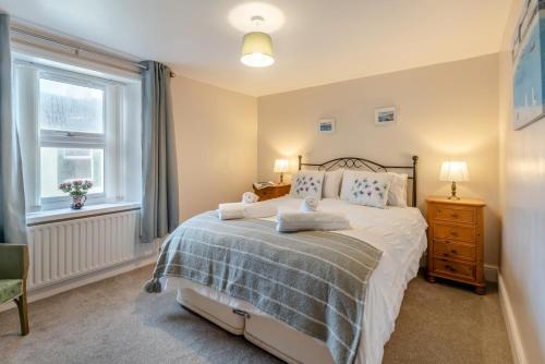 a bedroom with a bed and a window at Iona Cottage - Allonby in Allonby