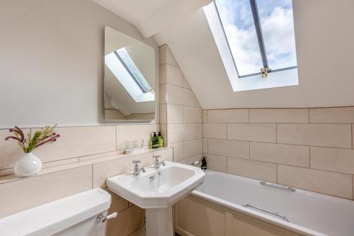 Un baño con lavabo, bañera y espejo. en Comus - Ludlow Castle, en Ludlow