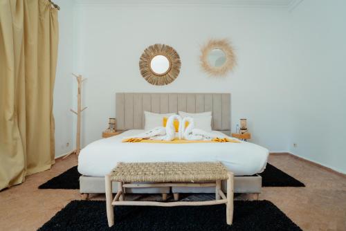 a bedroom with a large white bed and a mirror at DOMAINE DU DOUAR in Marrakech