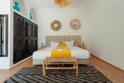 a bedroom with a king sized bed with a yellow blanket at DOMAINE DU DOUAR in Marrakech