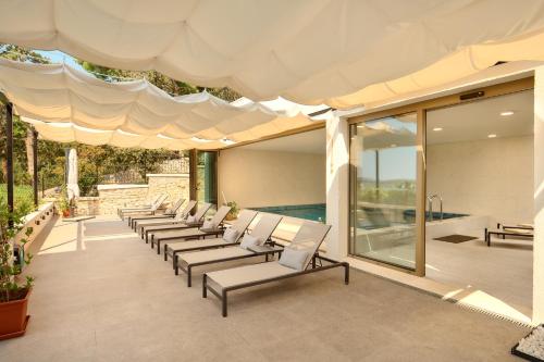 a row of lounge chairs under a canopy on a patio at Hotel Moeesy, Blue & Green Oasis in Hvar