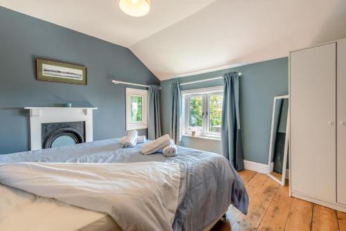 a bedroom with a large bed with blue walls at Laurel Cottage - The Retreat in Malvern Wells
