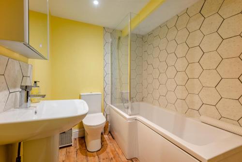a bathroom with a sink and a tub and a toilet at Laurel Cottage - The Retreat in Malvern Wells